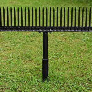 Bully Tools thatching rake with 24 tempered steel tines standing on a green lawn